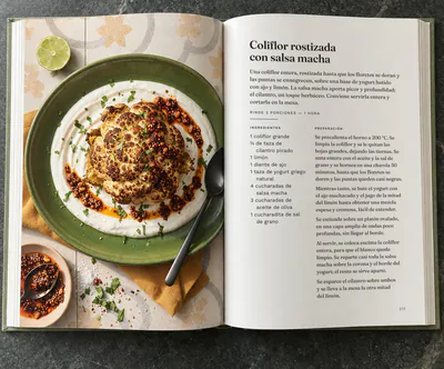 Un libro de cocina abierto en la receta de Coliflor rostizada con salsa macha